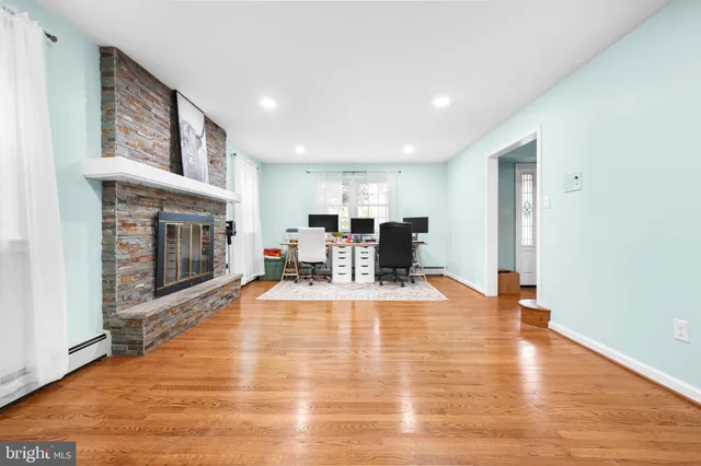 a open kitchen with white cabinets and wooden floors