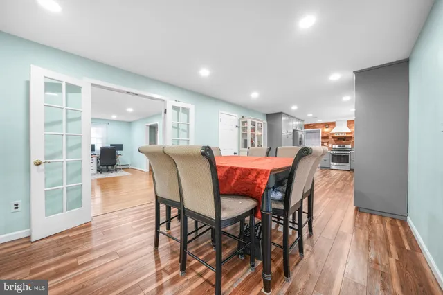 a large white kitchen with wooden floor and a sink