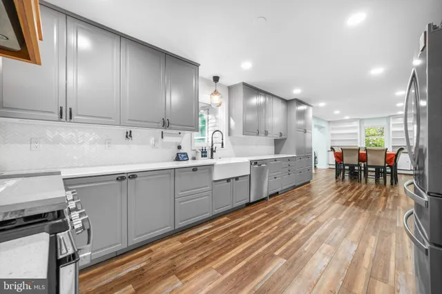 a view of a hallway with wooden floor and a bathroom