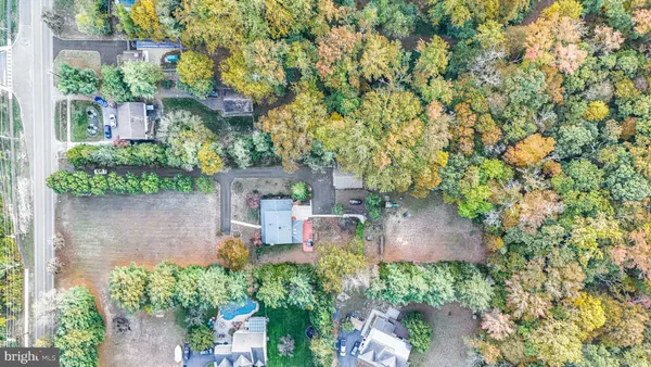 an aerial view of a house with a yard and large trees