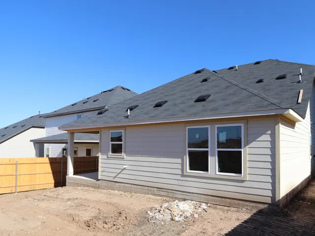 a view of a wooden bench under a large tree