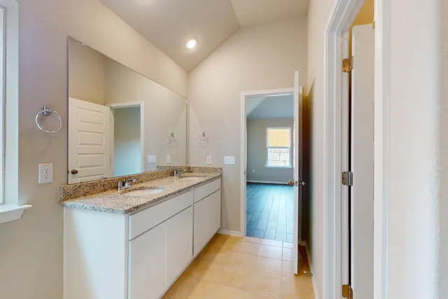 a spacious bathroom with a granite countertop sink and a mirror