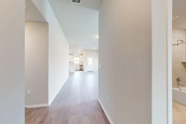 a view of a hallway with wooden floor