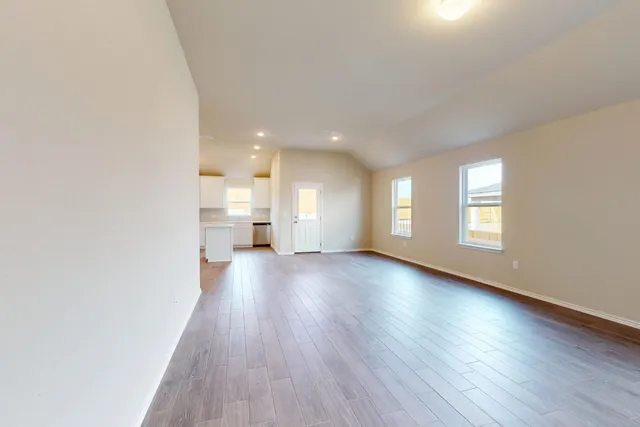 a view of empty room with wooden floor