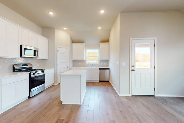 a kitchen with a refrigerator and a stove top oven