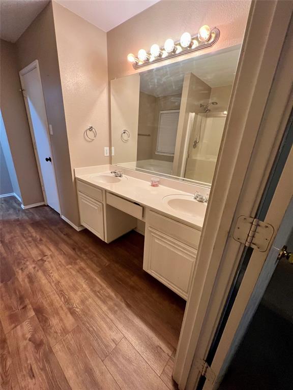12201 Rolling Ridge Drive Fort Worth, TX 76028 - Photo 14 of 21 Wood-finish flooring throughout, featuring a double vanity with integrated sinks and a spacious countertop