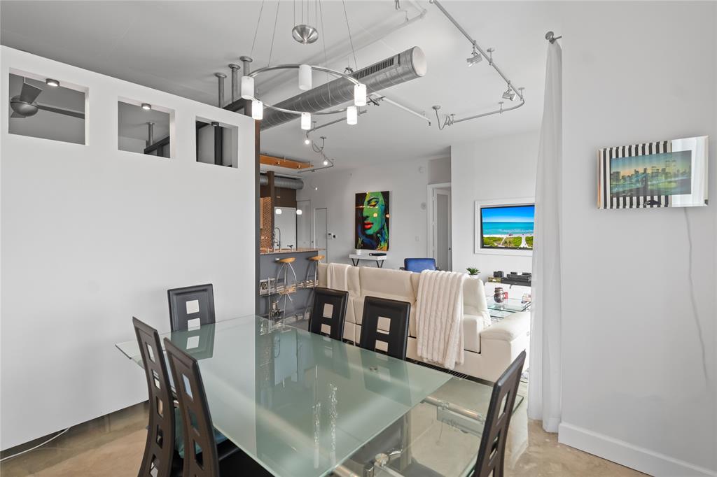 313 Northeast 2nd Street, Unit 405 Fort Lauderdale, FL 33301 - Photo 11 of 49 a dining room with kitchen island stainless steel appliances furniture a dining table and chairs