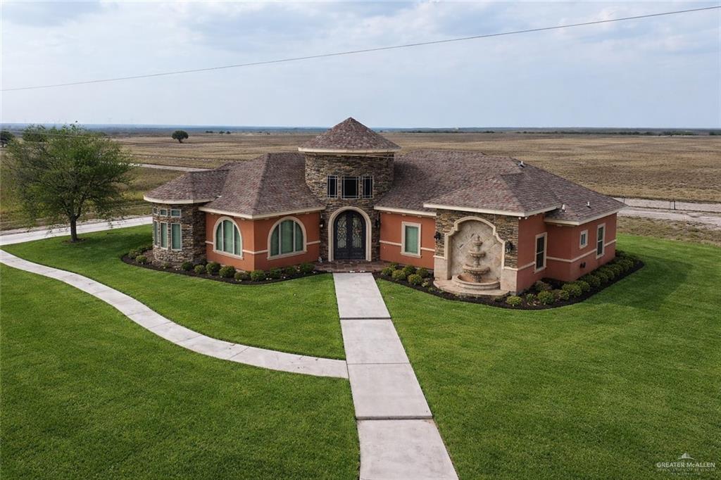 a aerial view of a house with a big yard plants and large trees