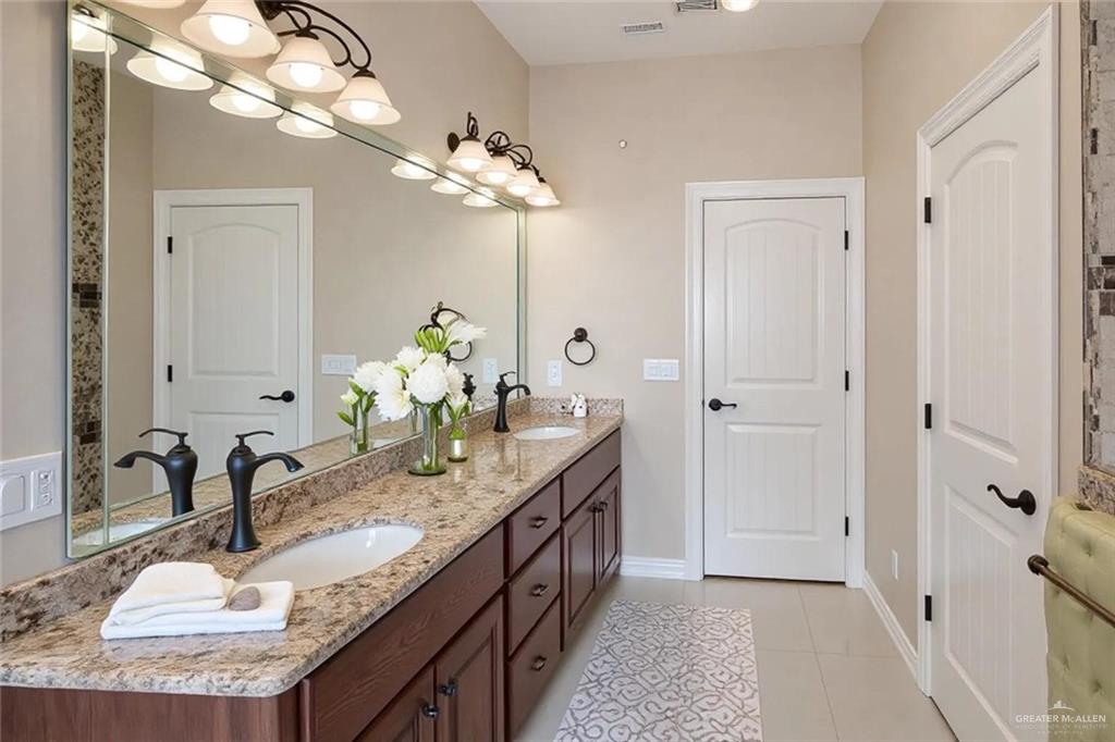 1339N North FM 649 Rio Grande City, TX 78582 - Photo 17 of 37 a bathroom with a granite countertop double vanity sink and a mirror