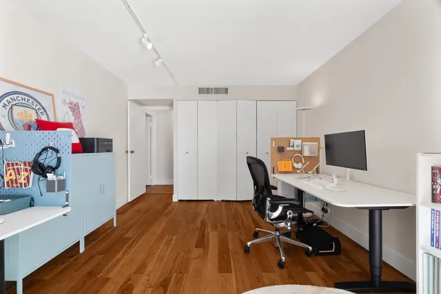 a view of a workspace with furniture and wooden floor