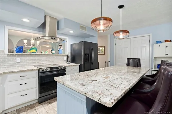 a kitchen with stainless steel appliances granite countertop stove top oven and cabinets