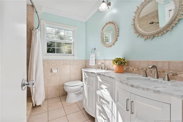 a bathroom with a granite countertop toilet a sink and a mirror