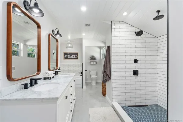 a bathroom with a double vanity sink a mirror and shower