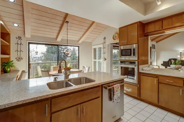 a kitchen with stainless steel appliances granite countertop a sink a stove and a refrigerator