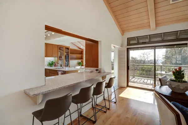 a dining room with furniture and a floor to ceiling window