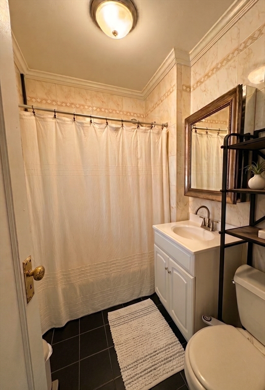 98 Strathmore Road, Unit 2 Boston, MA 02135 - Photo 8 of 11 a bathroom with a sink a toilet a mirror and shower curtain
