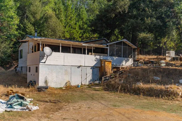 a view of a house with backyard and trees