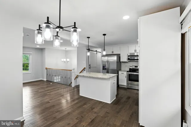 a view of kitchen and living room with wooden floor