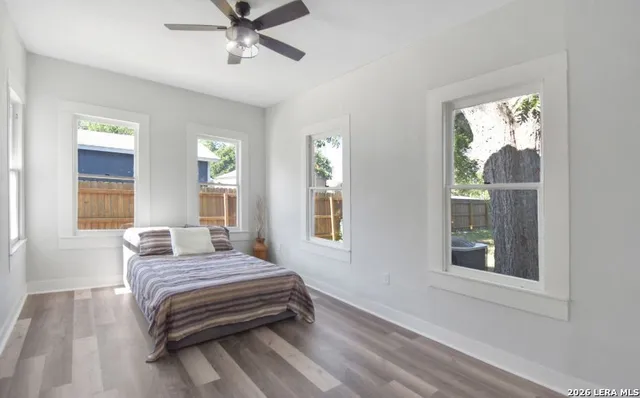 a view of empty room with wooden floor and fan