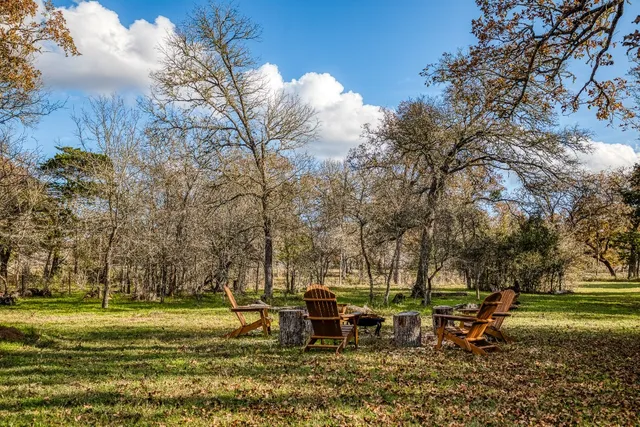 a front view of a house with a garden and tree