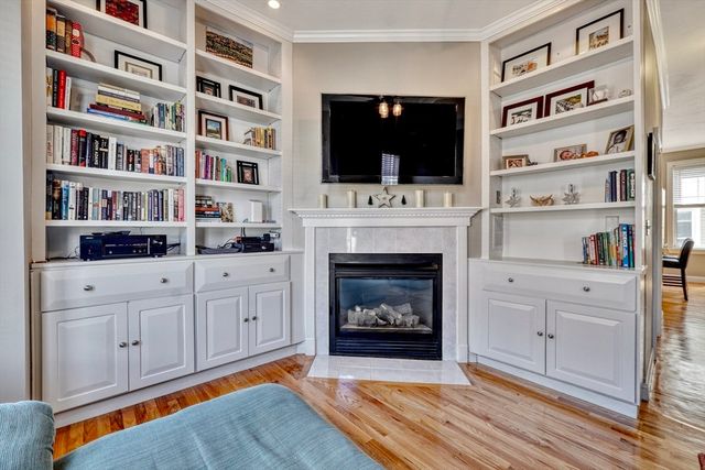 a living room with hard wood floors and a fireplace
