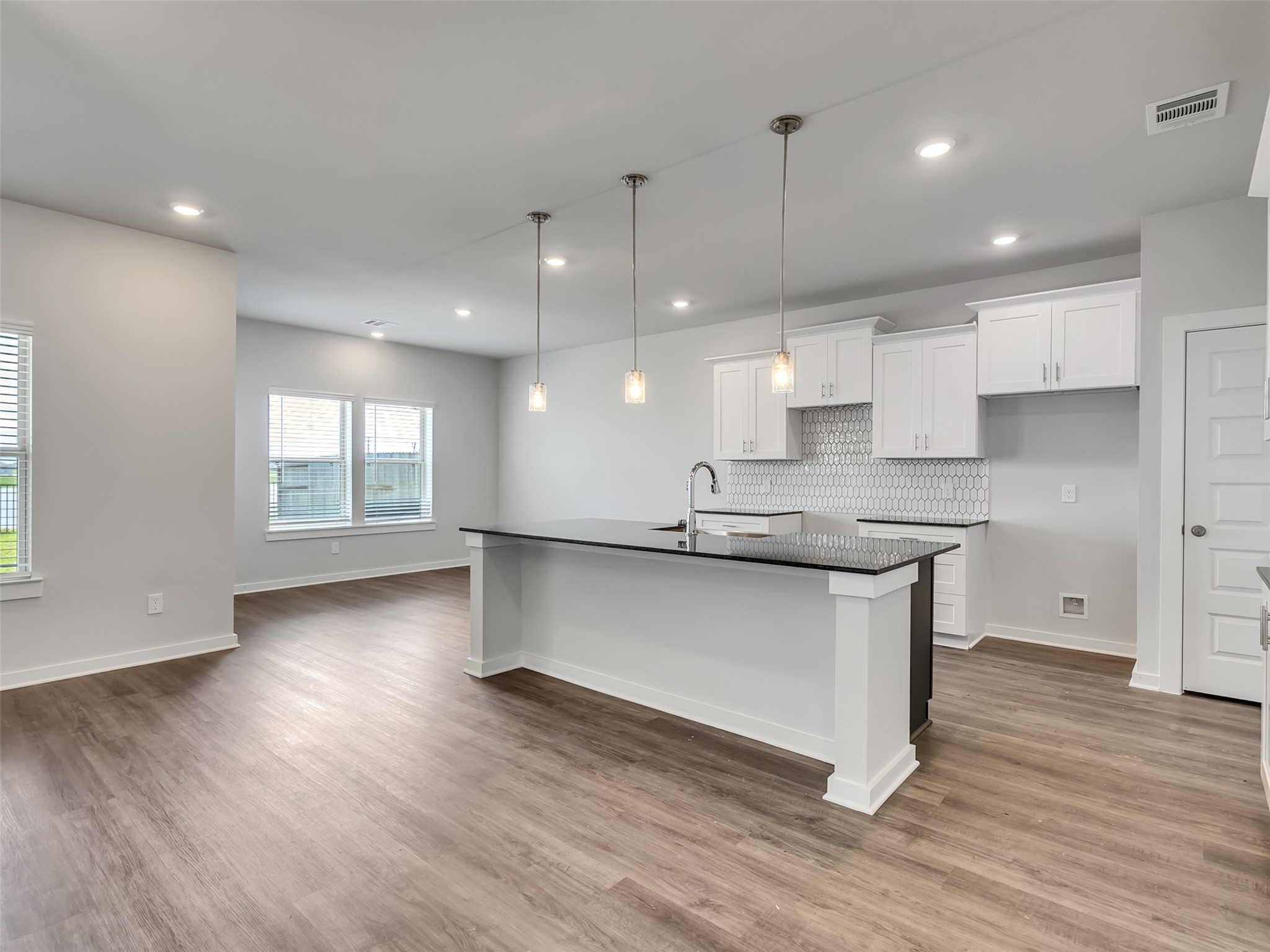 1206 Elsinore Drive Rosharon, TX 77583 - Photo 6 of 21 a open kitchen with kitchen island a sink dishwasher a refrigerator and white cabinets with wooden floor