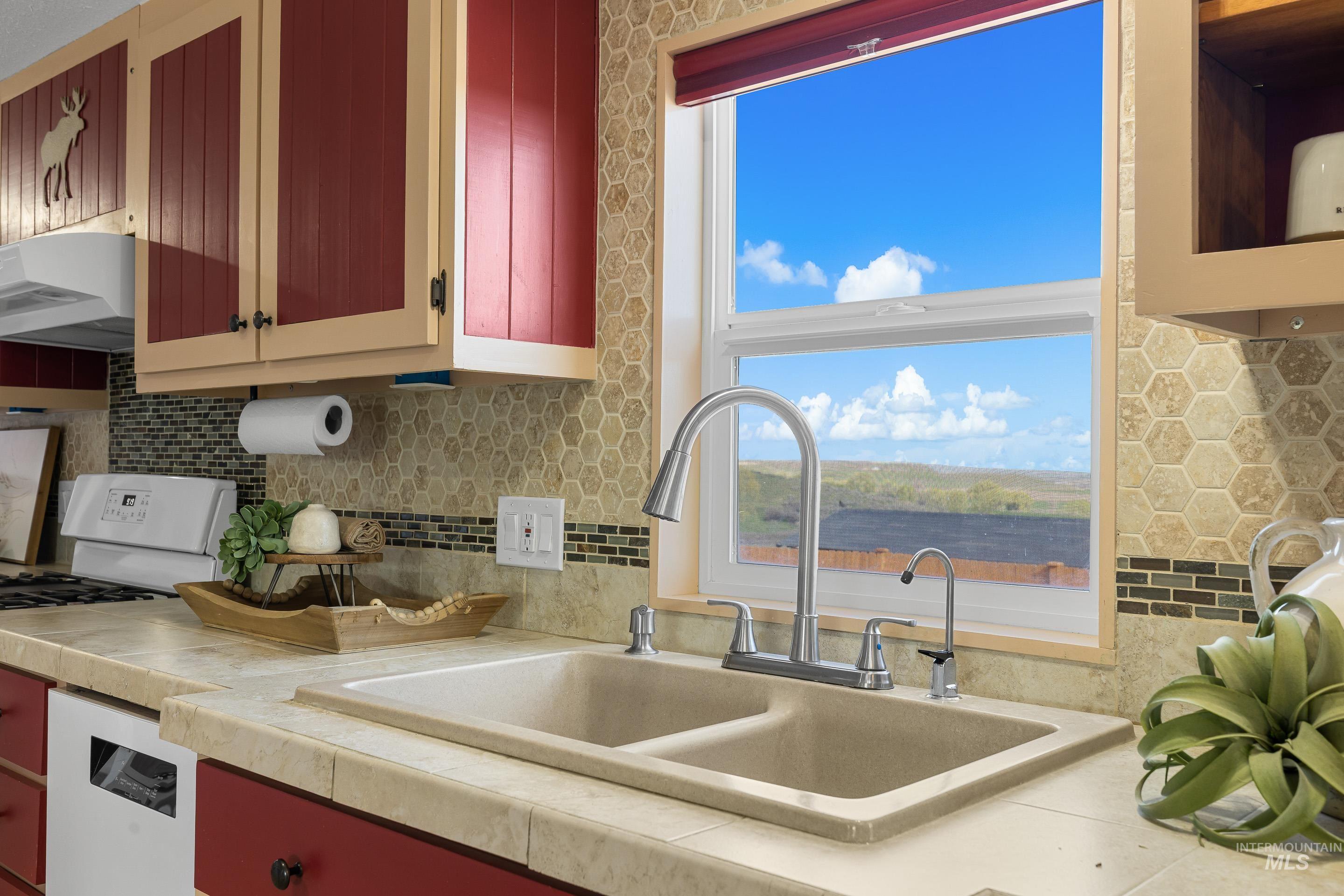 2427 Northside Road Homedale, ID 83628 - Photo 12 of 49 Kitchen with backsplash, white appliances, exhaust hood, and red cabinets