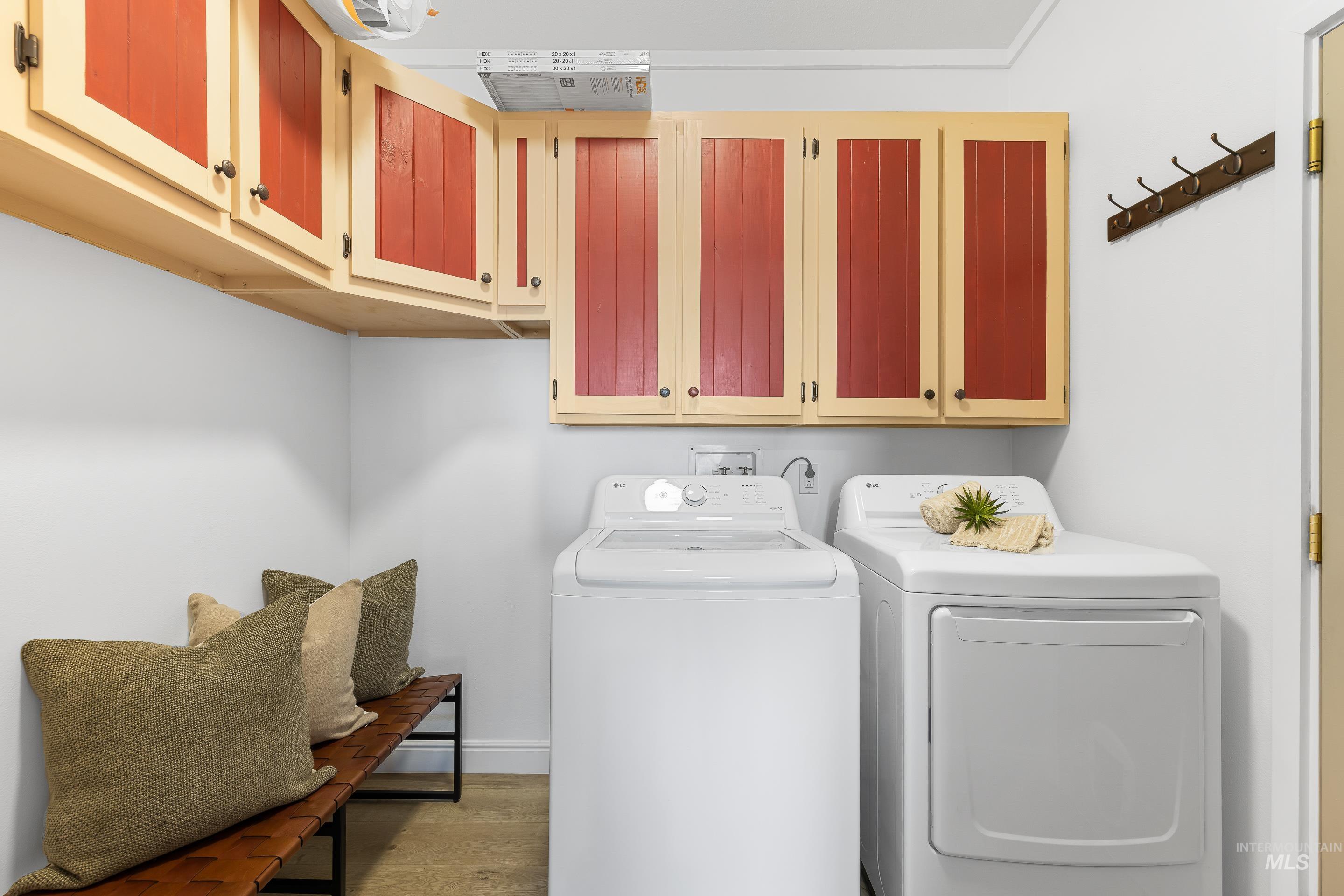 2427 Northside Road Homedale, ID 83628 - Photo 15 of 49 Laundry room with washer and dryer, light wood-type flooring, and cabinet space