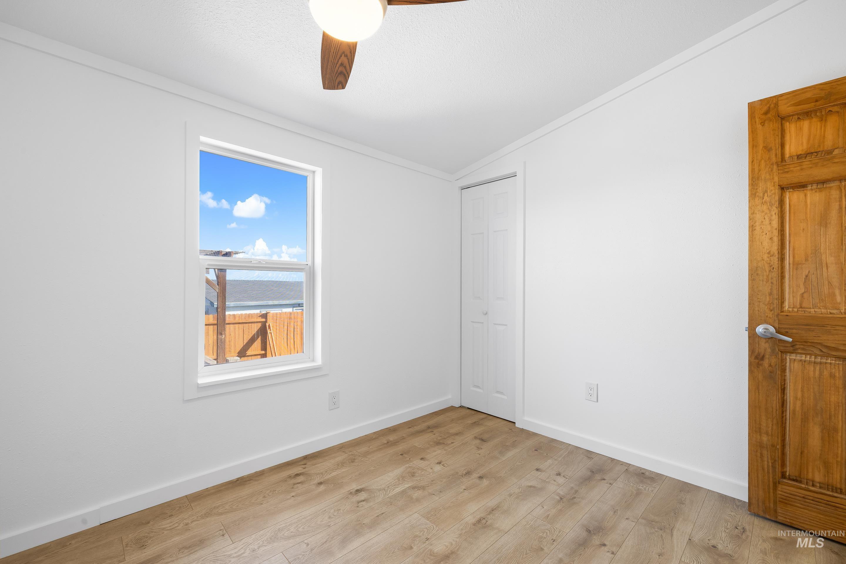 2427 Northside Road Homedale, ID 83628 - Photo 21 of 49 Unfurnished bedroom with lofted ceiling, light wood-type flooring, ornamental molding, ceiling fan, and a closet