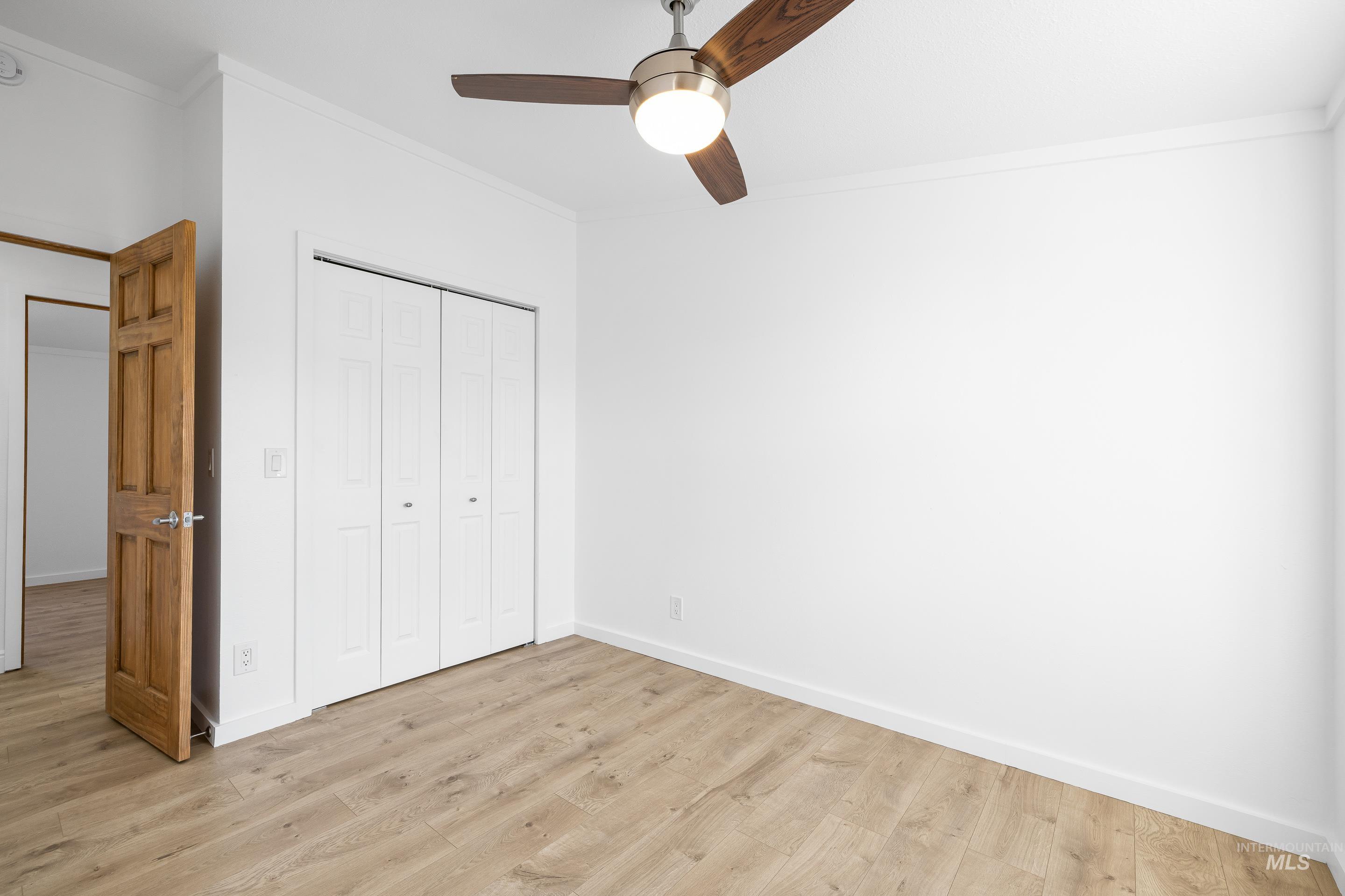 2427 Northside Road Homedale, ID 83628 - Photo 23 of 49 Unfurnished bedroom featuring crown molding, a closet, light wood-style floors, and ceiling fan