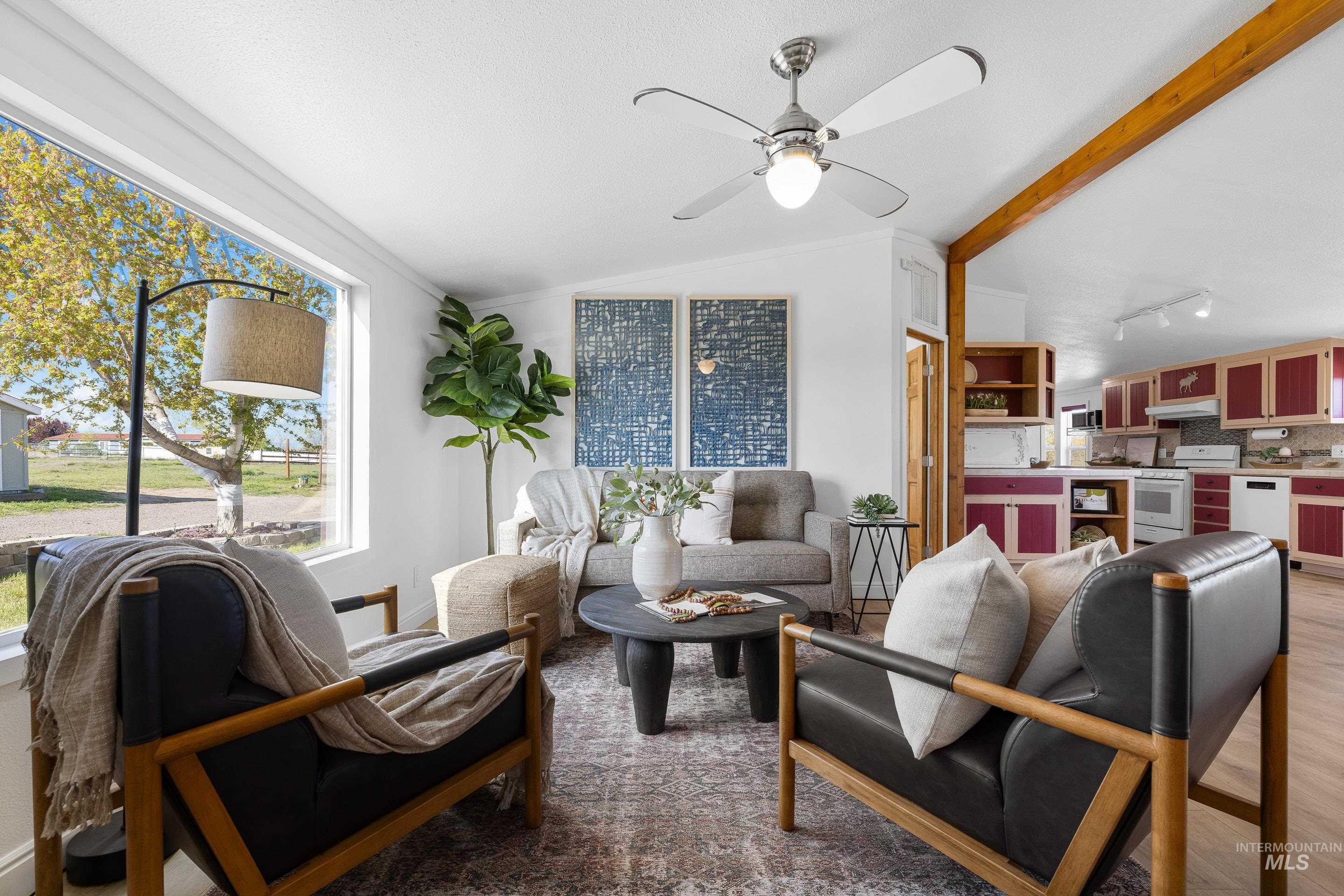 2427 Northside Road Homedale, ID 83628 - Photo 5 of 49 Living room featuring vaulted ceiling with beams, ceiling fan, light wood-style flooring, and rail lighting