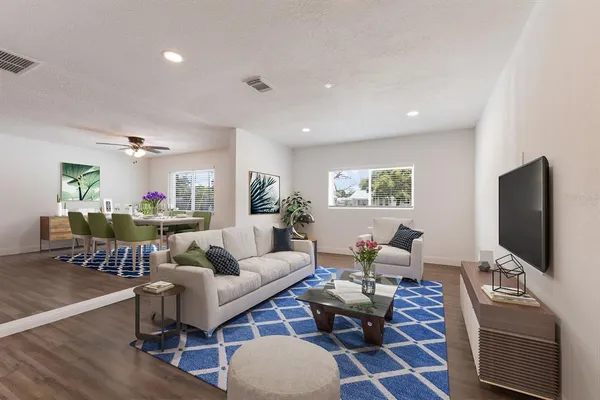 a living room with furniture a rug and a flat screen tv