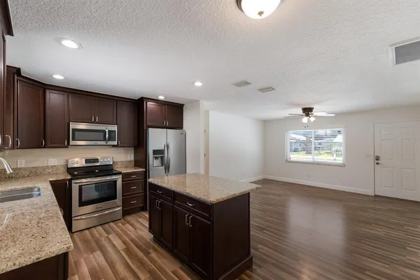 a kitchen with stainless steel appliances granite countertop a stove a sink and a refrigerator