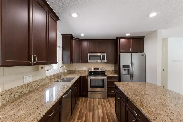 a kitchen with stainless steel appliances granite countertop sink microwave and stove