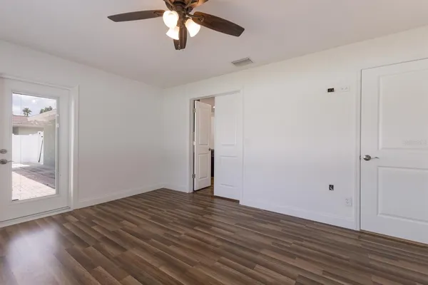 an empty room with wooden floor and windows