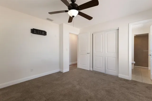 an empty room with closet and windows