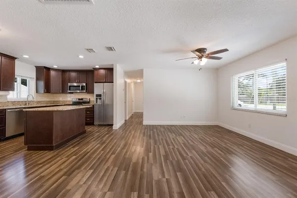 a view of kitchen with sink and refrigerator