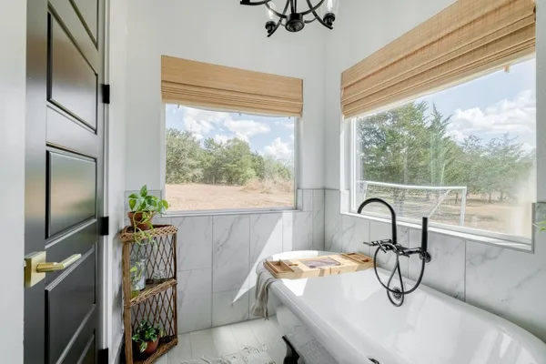 a bedroom with a bed and a large window with the outer view