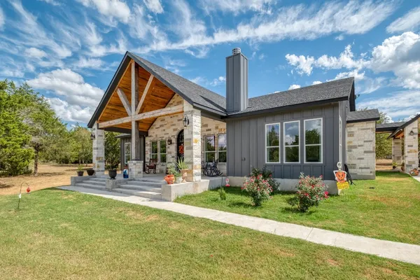 a front view of a house with garden and sitting area