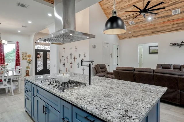 a kitchen with stainless steel appliances kitchen island granite countertop a table and chairs in it