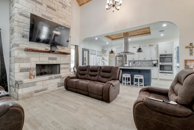 a living room with furniture a fireplace and a flat screen tv