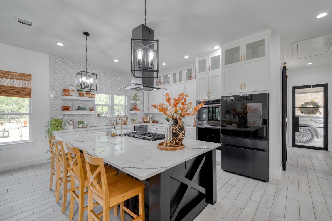 1901 Highway 21, Unit B Paige, TX 78659 - Photo 6 of 40 a kitchen with stainless steel appliances granite countertop a sink a stove a refrigerator and island with wooden floor