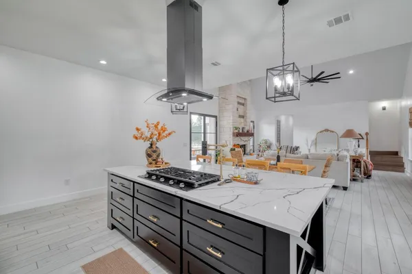 a kitchen with a counter space a stove and cabinets