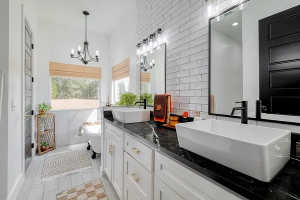 a spacious bathroom with a double vanity sink a mirror and a bathtub
