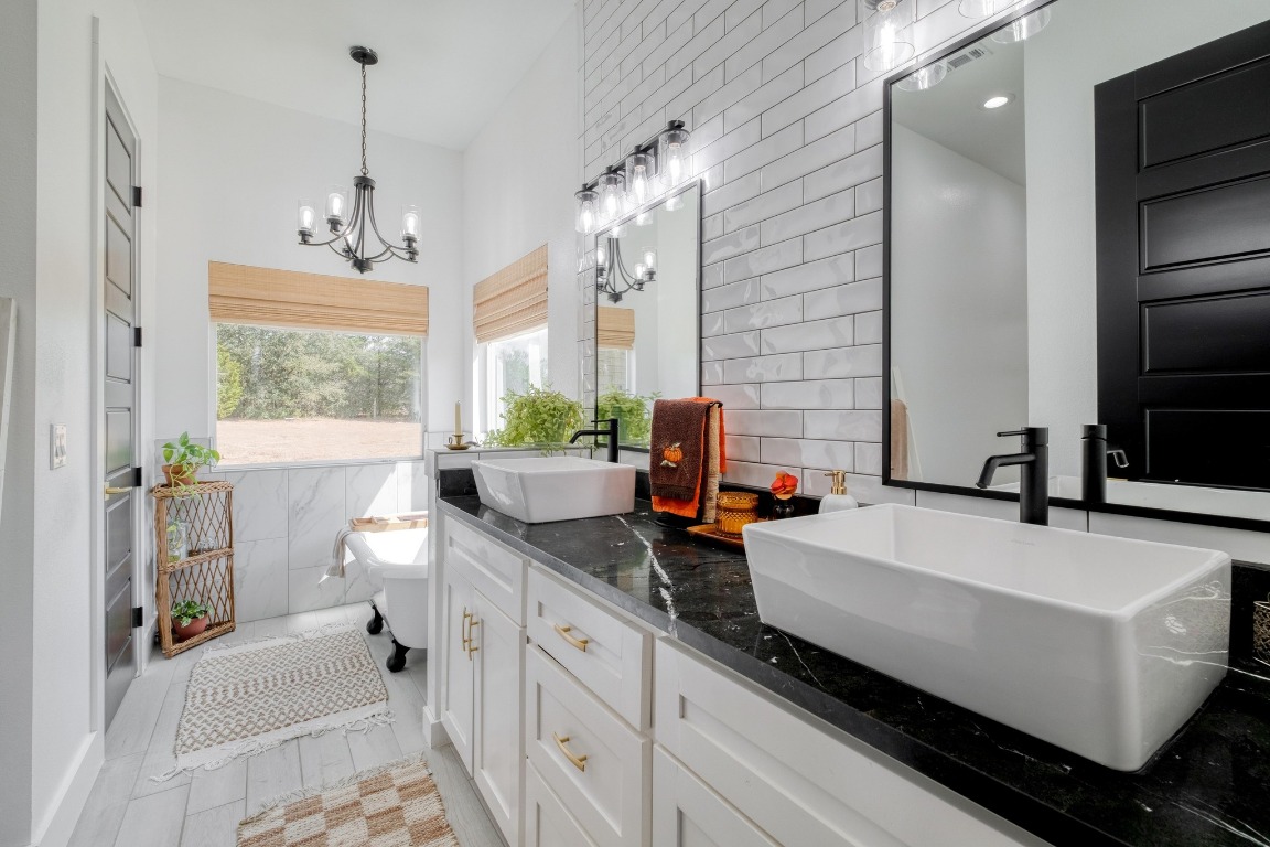 1901 Highway 21, Unit B Paige, TX 78659 - Photo 10 of 40 a spacious bathroom with a double vanity sink a mirror and a bathtub