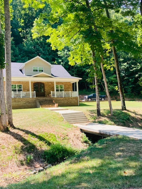 61 Spring Valley Road Taft, TN 38488 - Photo 3 of 29 a front view of a house with garden