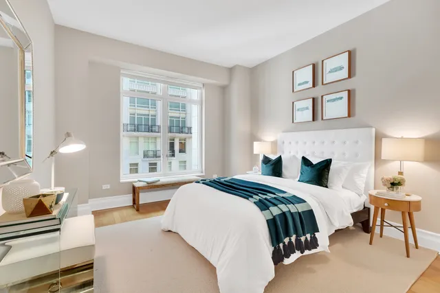 a bedroom with a bed and a lamp on dresser