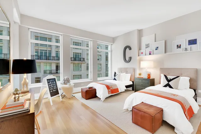 a bedroom with two beds and a large window