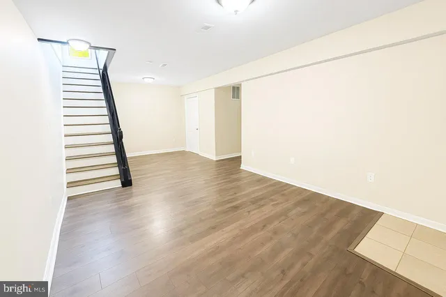 a view of a room with wooden floor and white walls