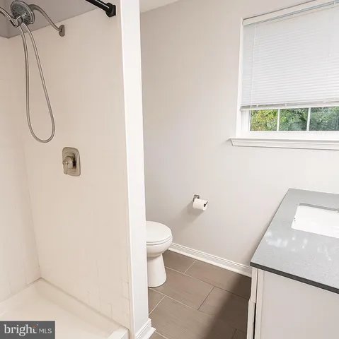 a bathroom with a granite countertop toilet and a sink